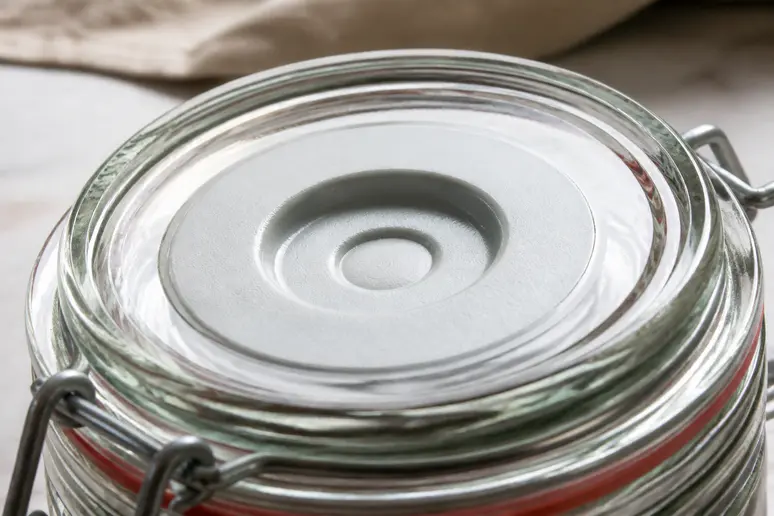 Einmachglasdeckel mit 'Plopp'-Indikator zeigt erfolgreiche Vakuumversiegelung beim Einkochen